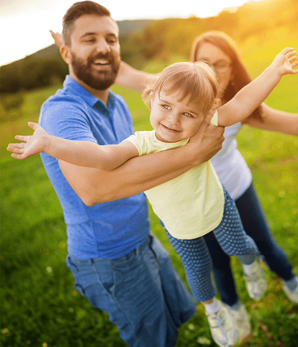 Parents playing with child outdoors